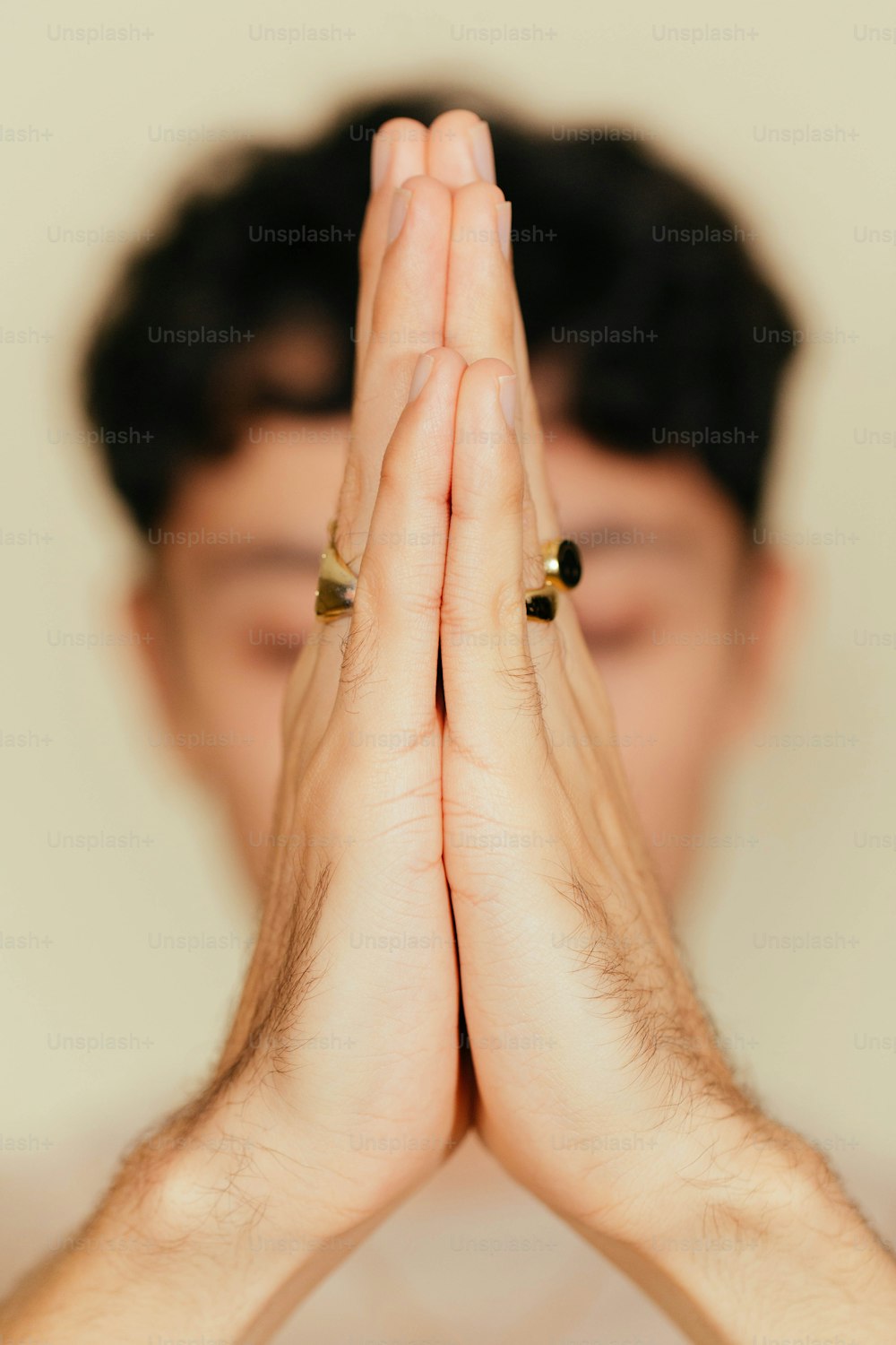Un hombre está sosteniendo sus manos juntas para orar
