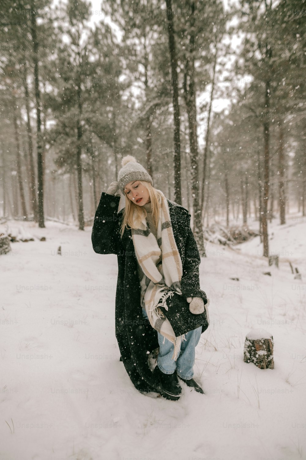 Una mujer está parada en la nieve en el bosque