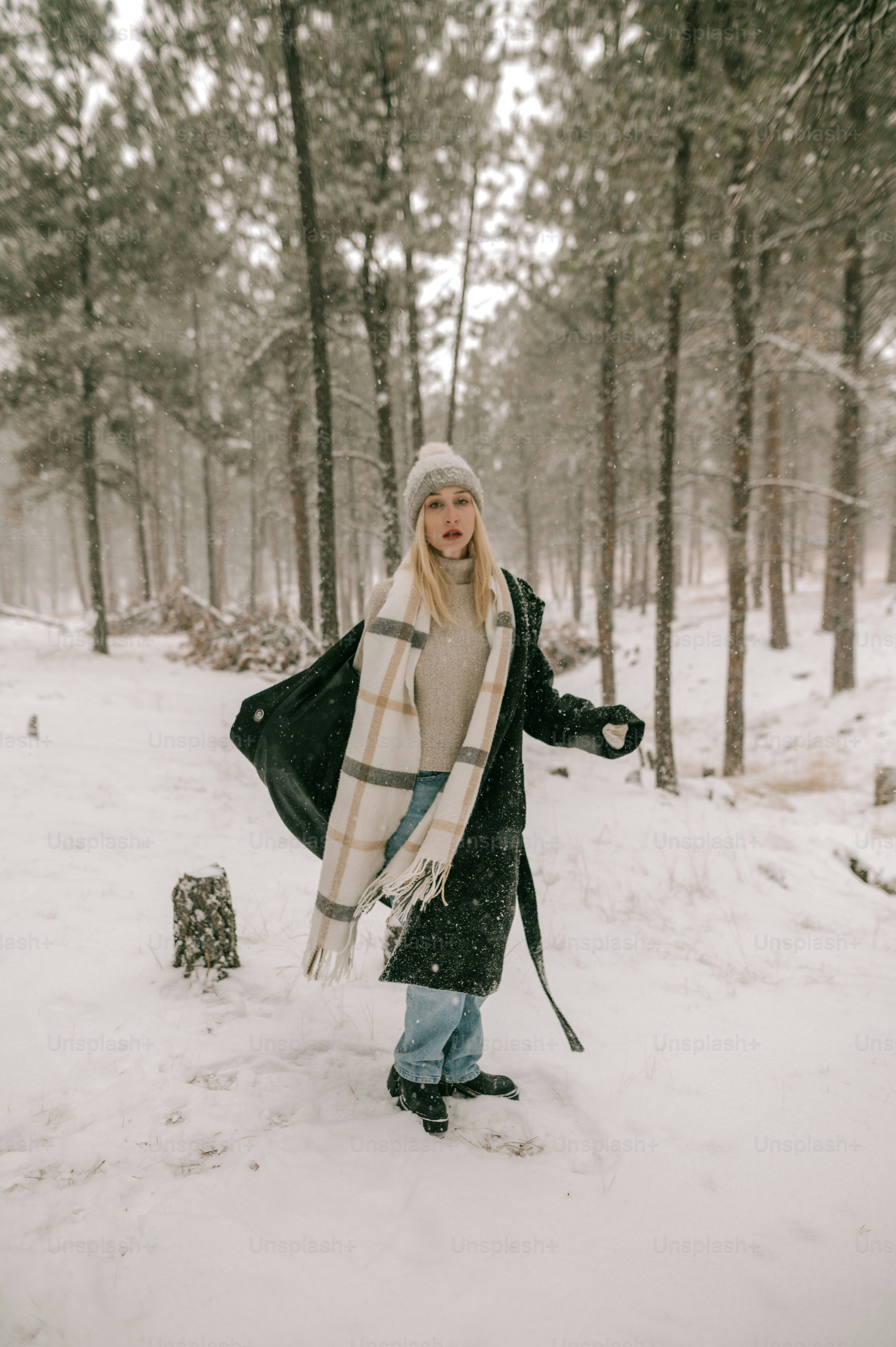 a woman standing in the snow with a scarf around her neck