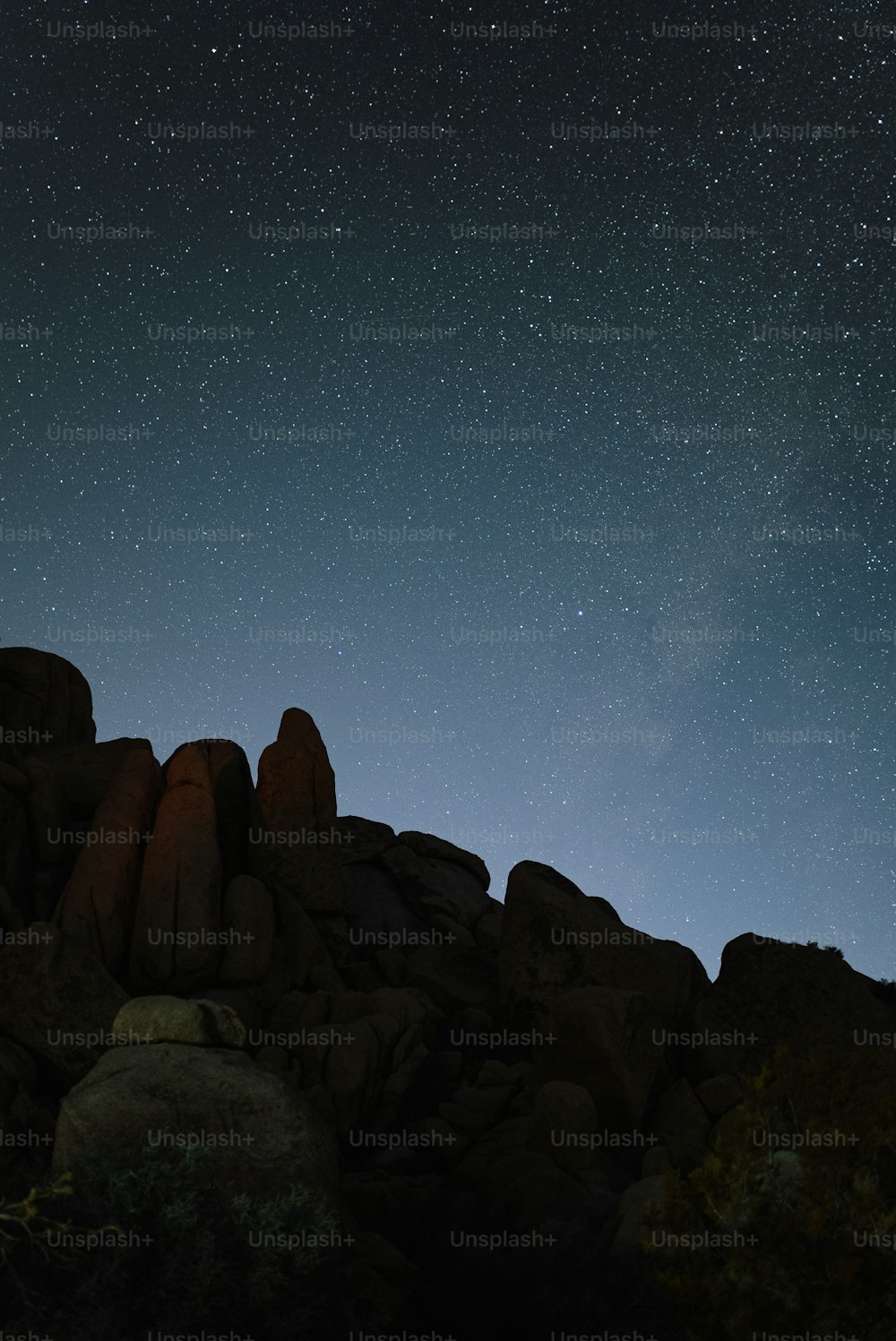 the night sky is full of stars and stars above some rocks