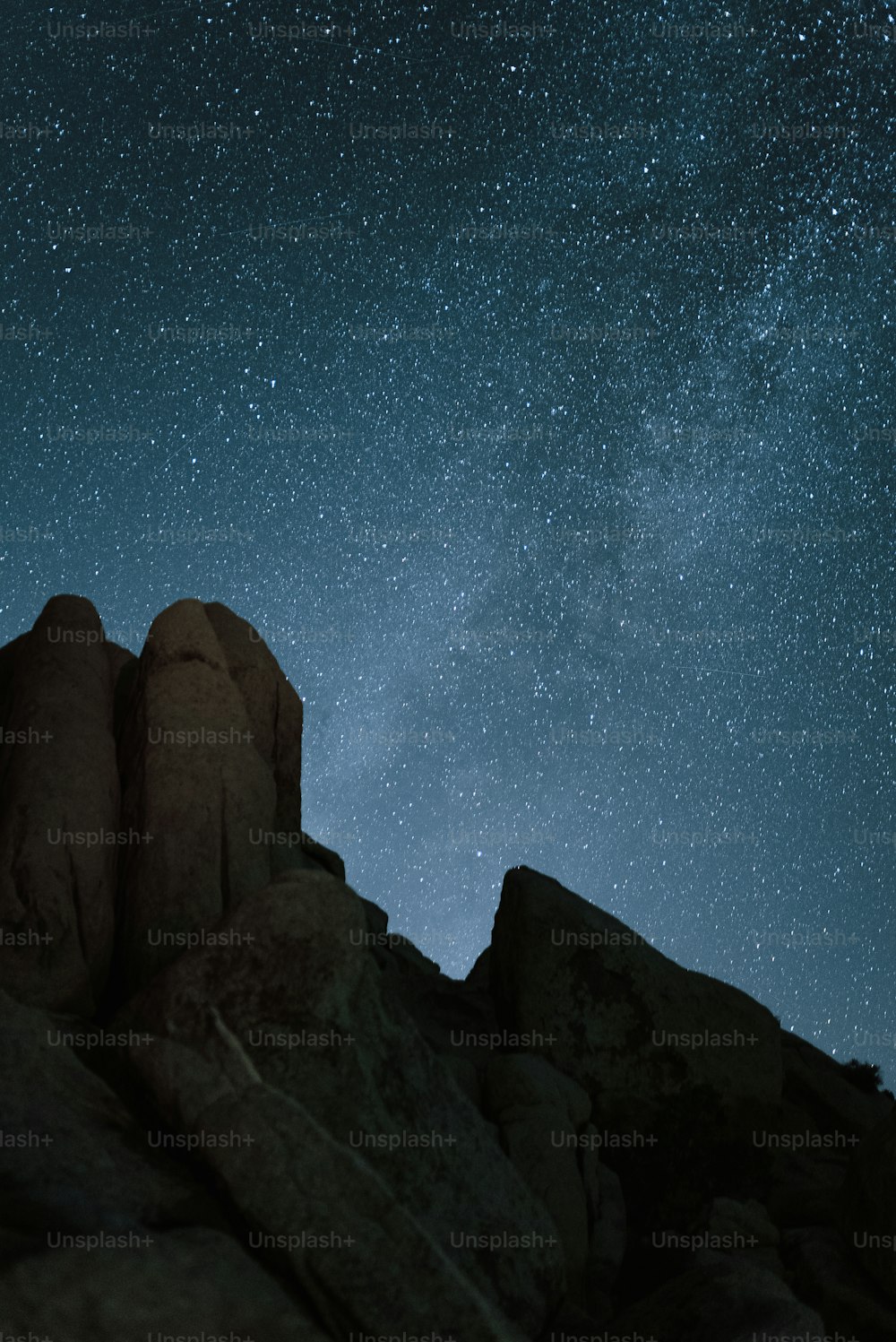 El cielo nocturno está lleno de estrellas sobre las rocas