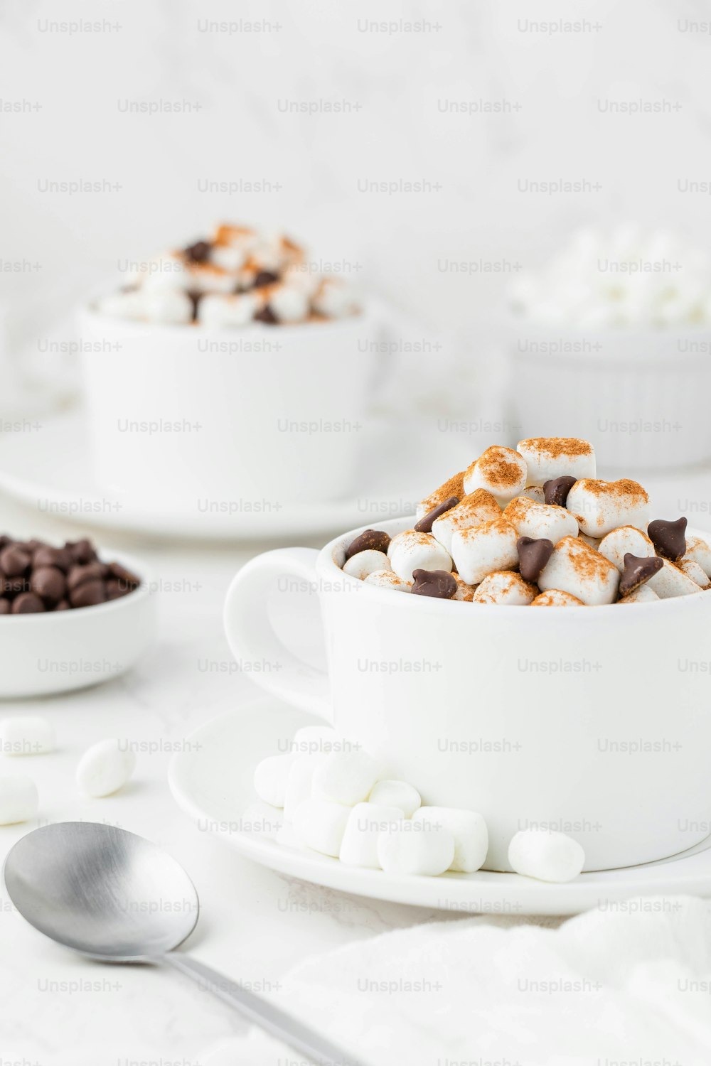 a cup of hot chocolate and marshmallows on a plate