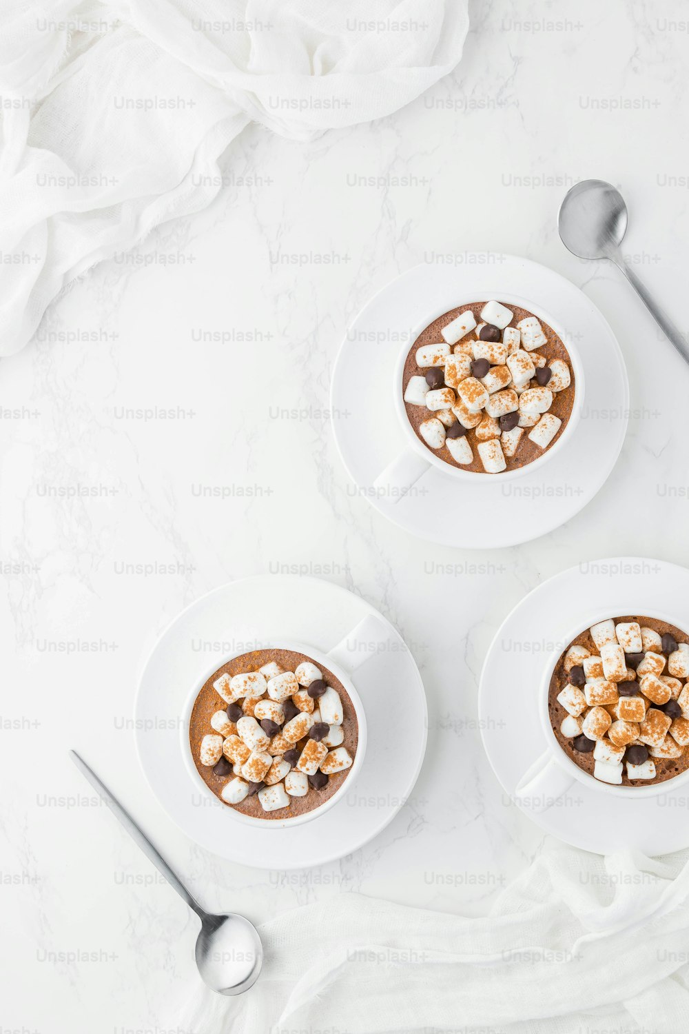 two cups of hot chocolate topped with marshmallows