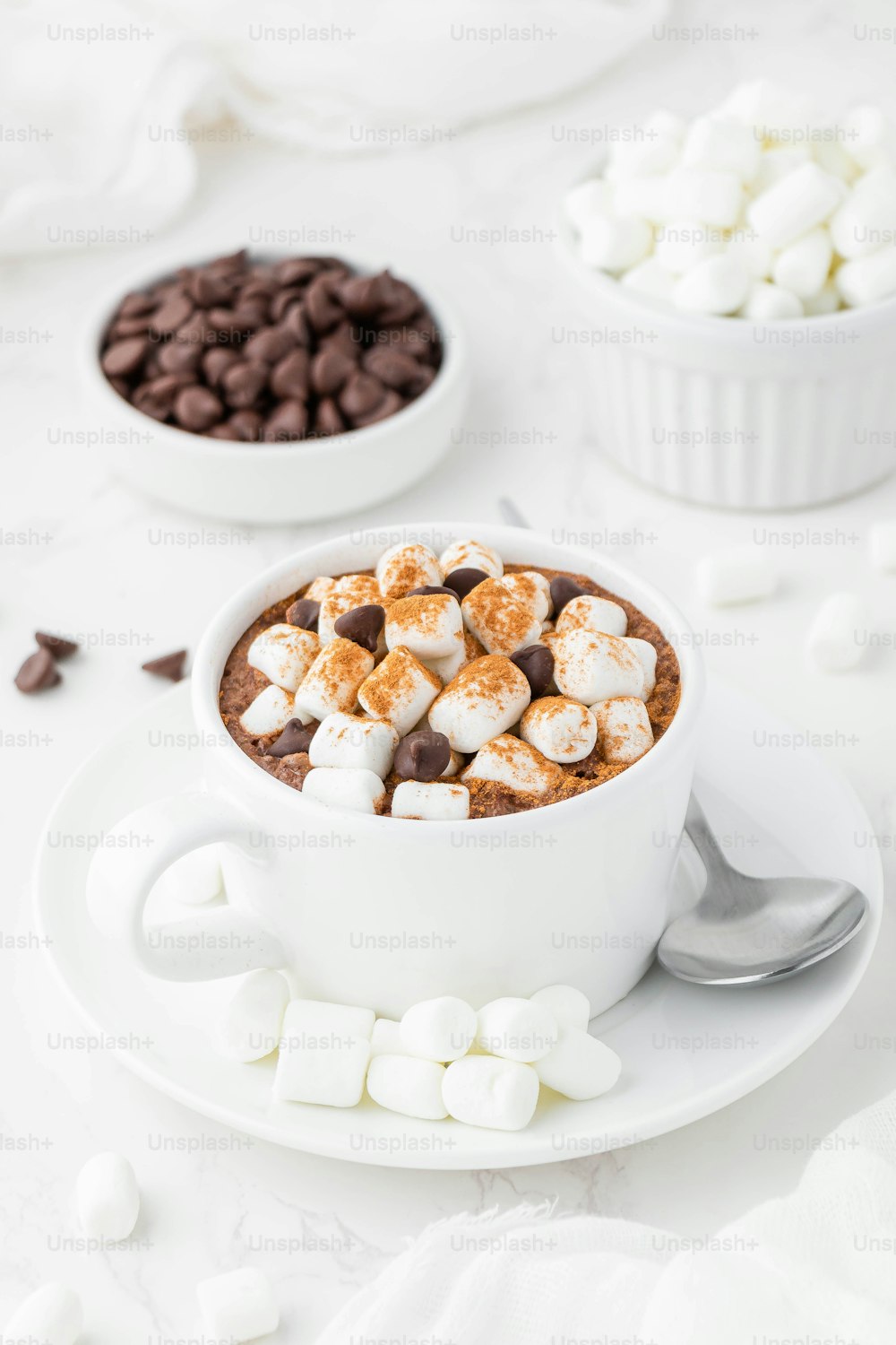 uma xícara de chocolate quente com marshmallows e lascas de chocolate
