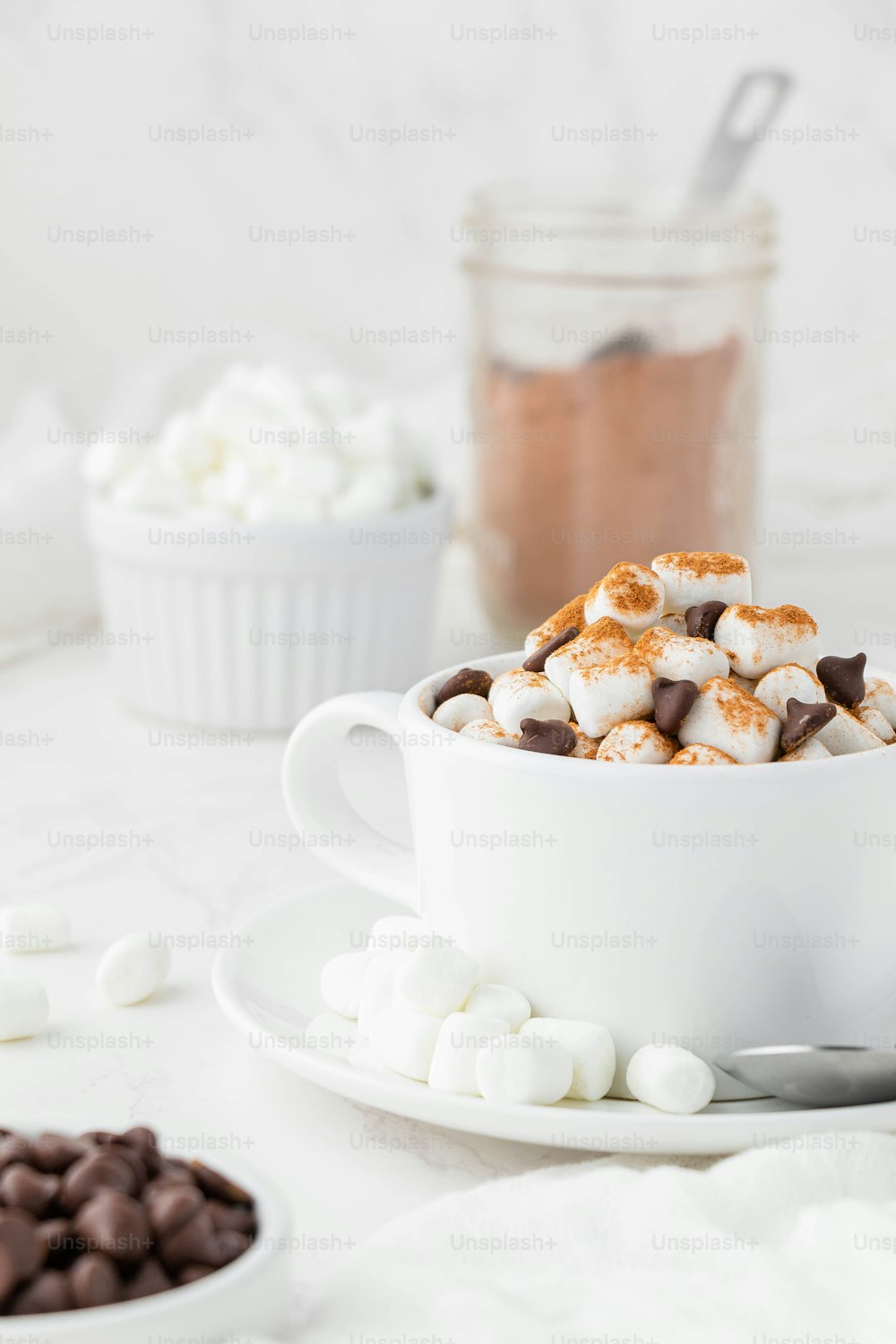 a cup of hot chocolate and marshmallows on a saucer