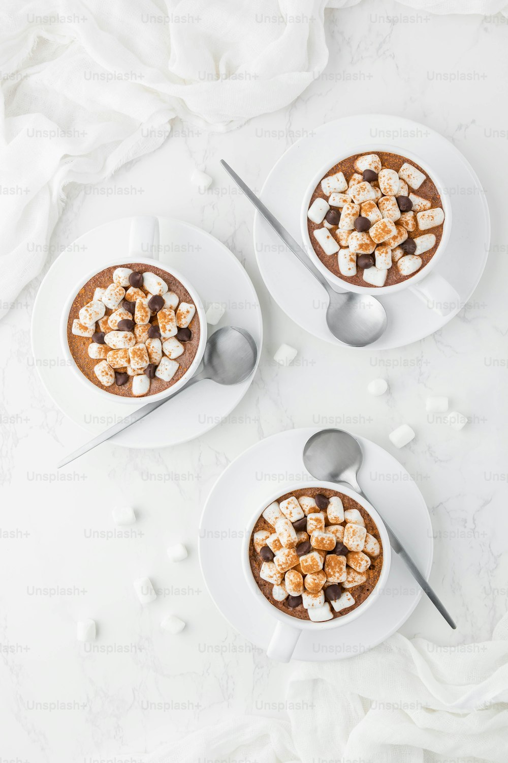 duas tigelas de chocolate quente cobertas com marshmallows
