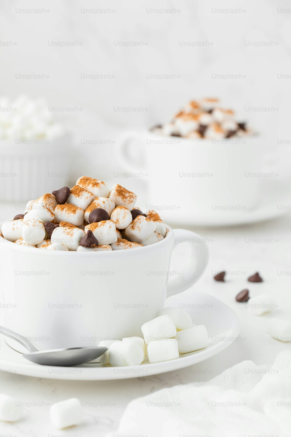 a cup of hot chocolate and marshmallows on a saucer