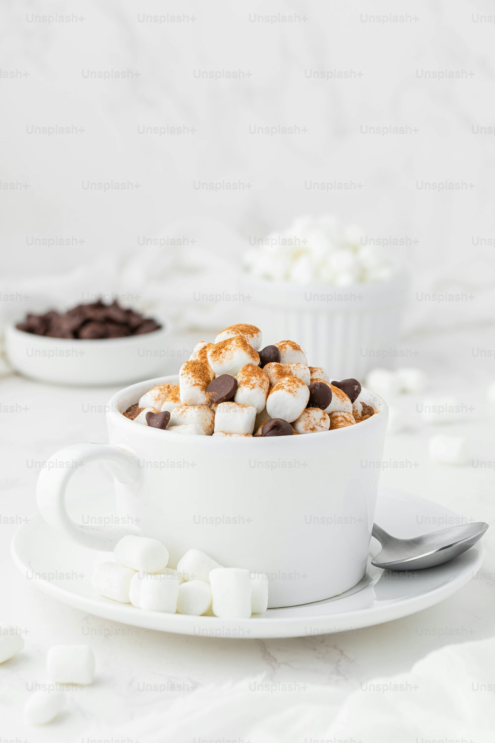 uma xícara de chocolate quente e marshmallows em um prato