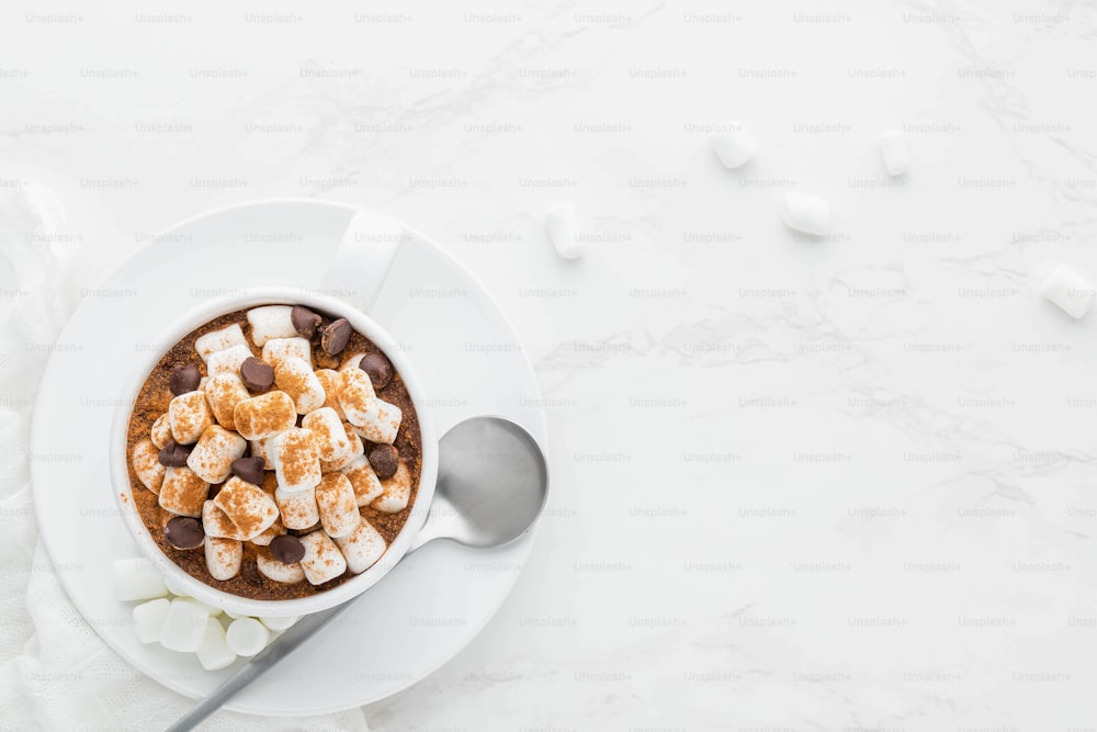 a bowl of hot chocolate with marshmallows and a spoon