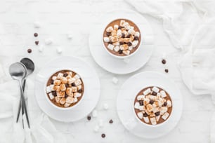 two cups of hot chocolate topped with marshmallows