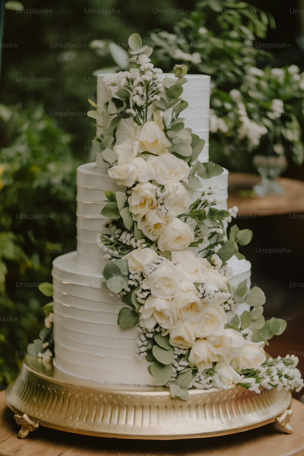 白い花と緑で飾られたウェディングケーキ