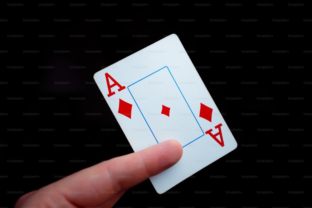 eine Hand, die eine Vierer-Spielkarte hält