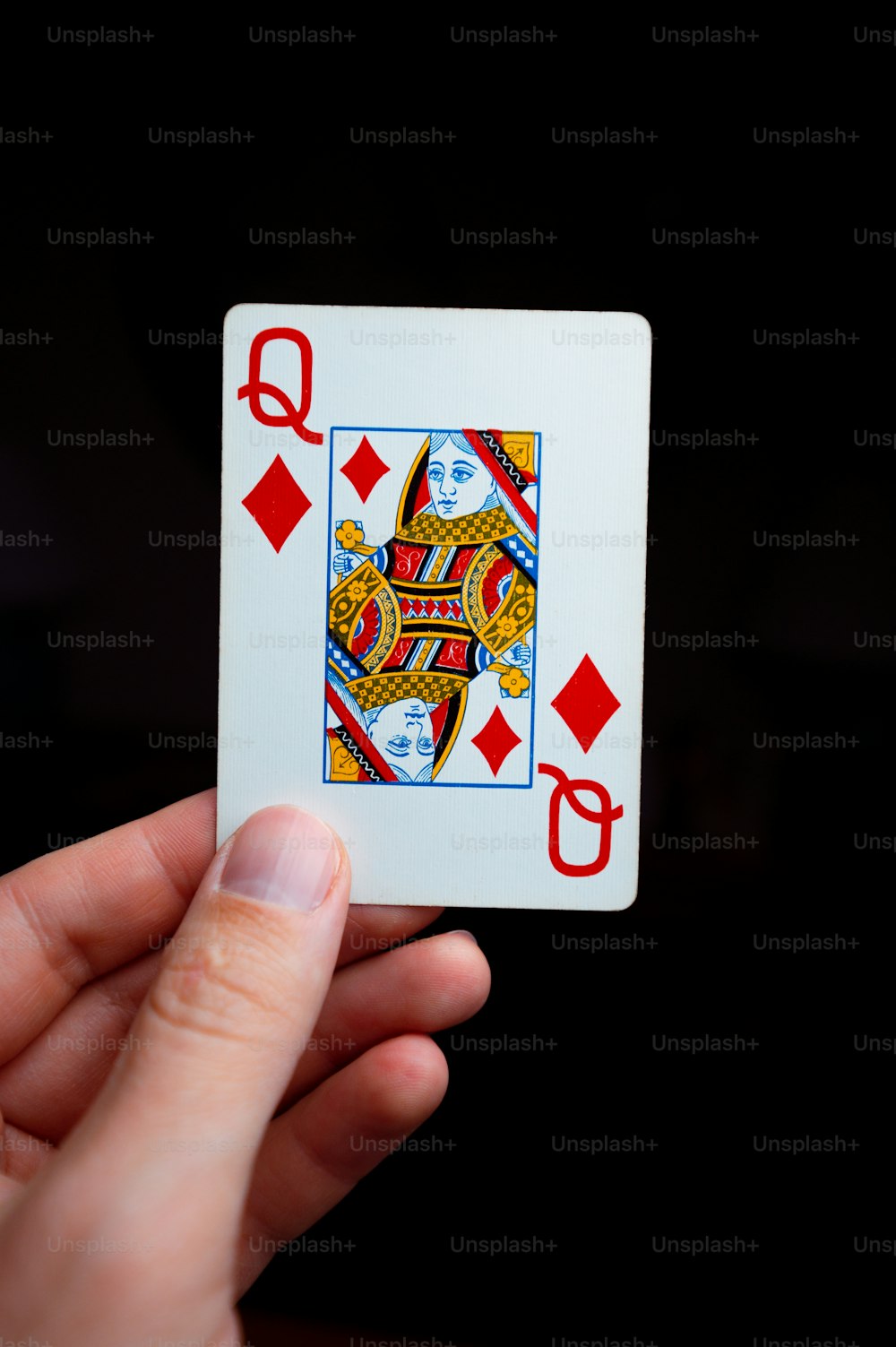una persona que sostiene una carta de juego en la mano
