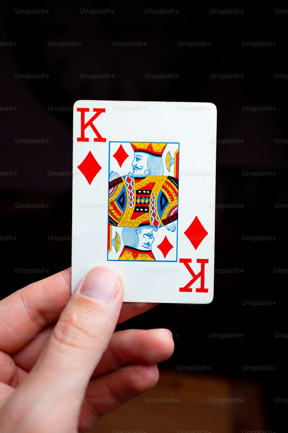 a person holding a playing card in their hand