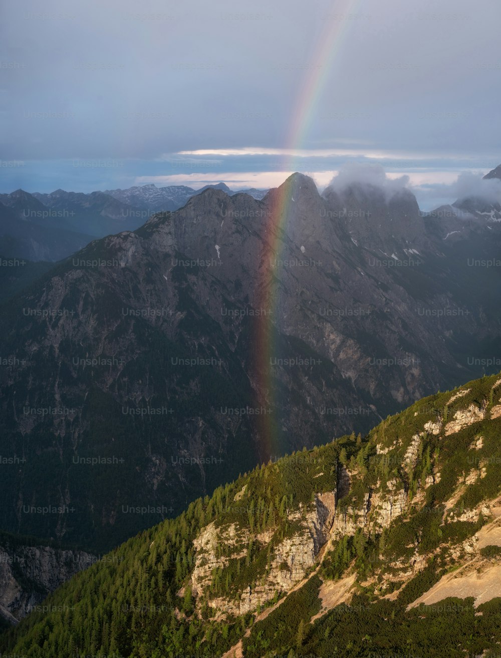 a rainbow in the sky over a mountain range