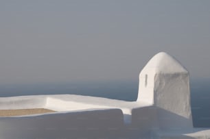 um edifício branco com um telhado feito de neve