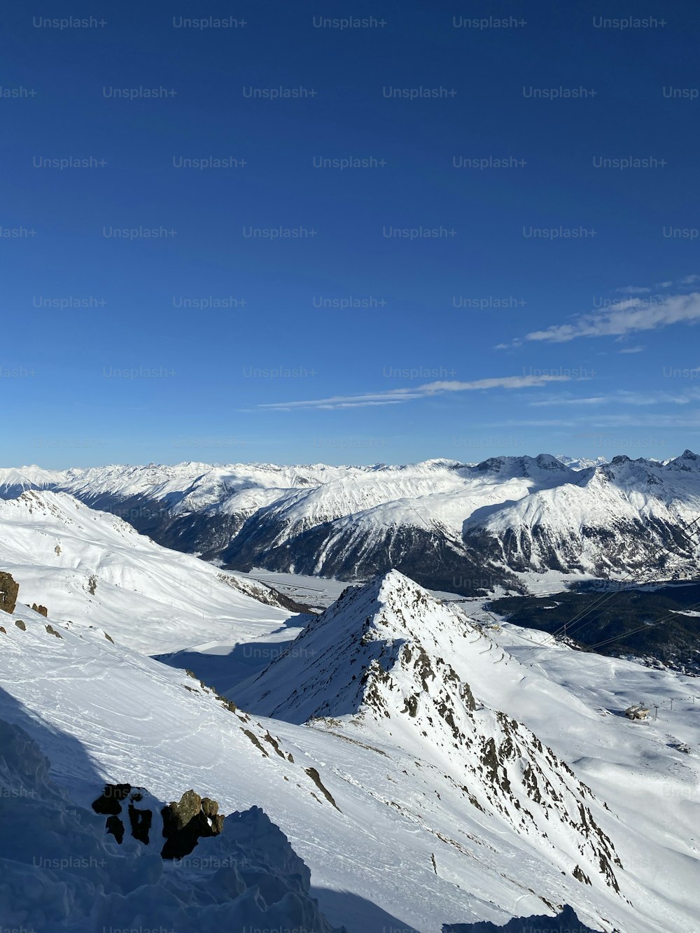 una persona in piedi sulla cima di una montagna coperta di neve