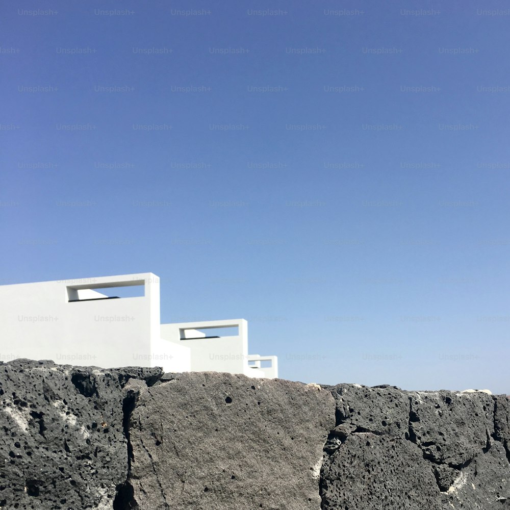 a white building sitting on top of a rocky hillside