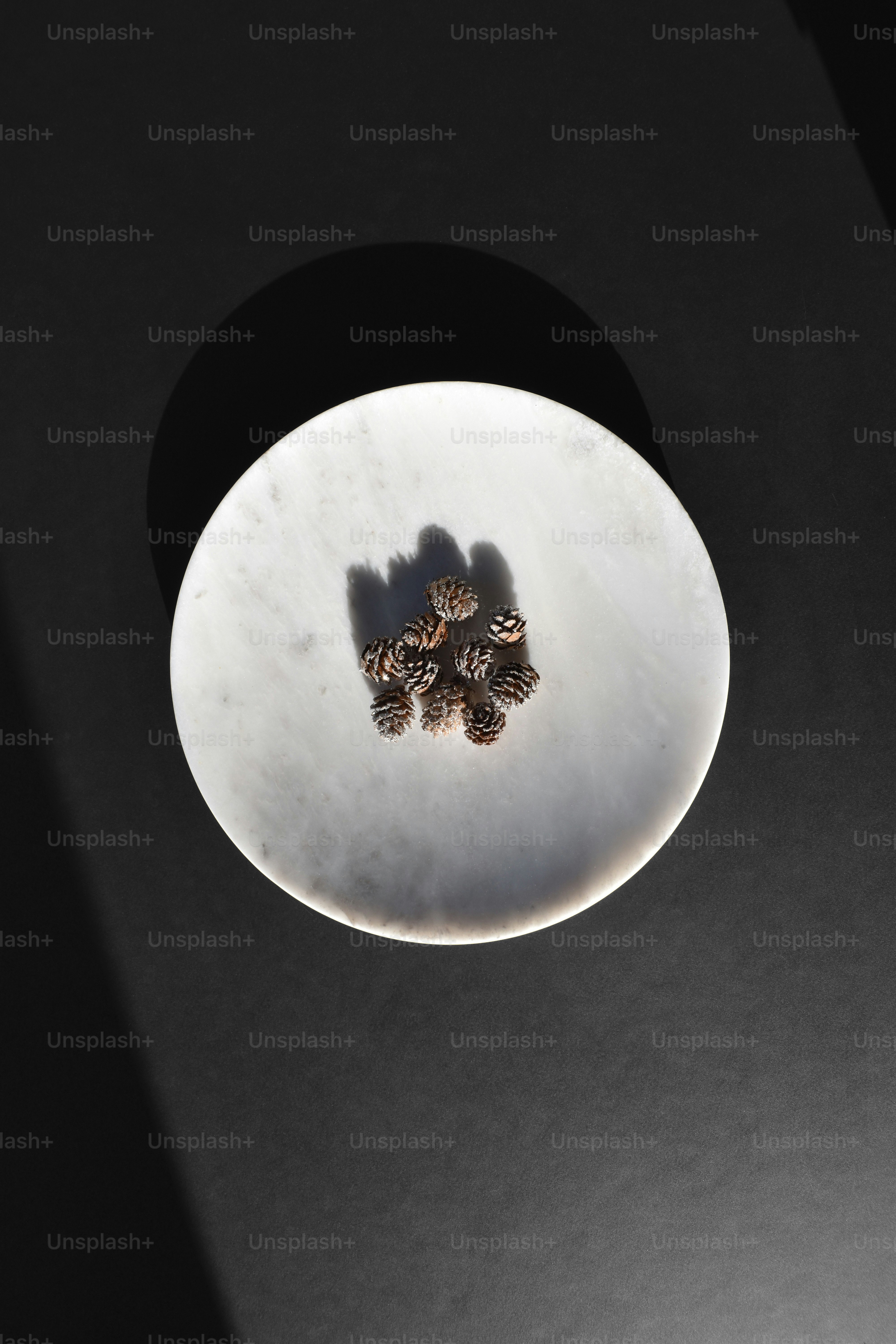 a white plate topped with pine cones on top of a table