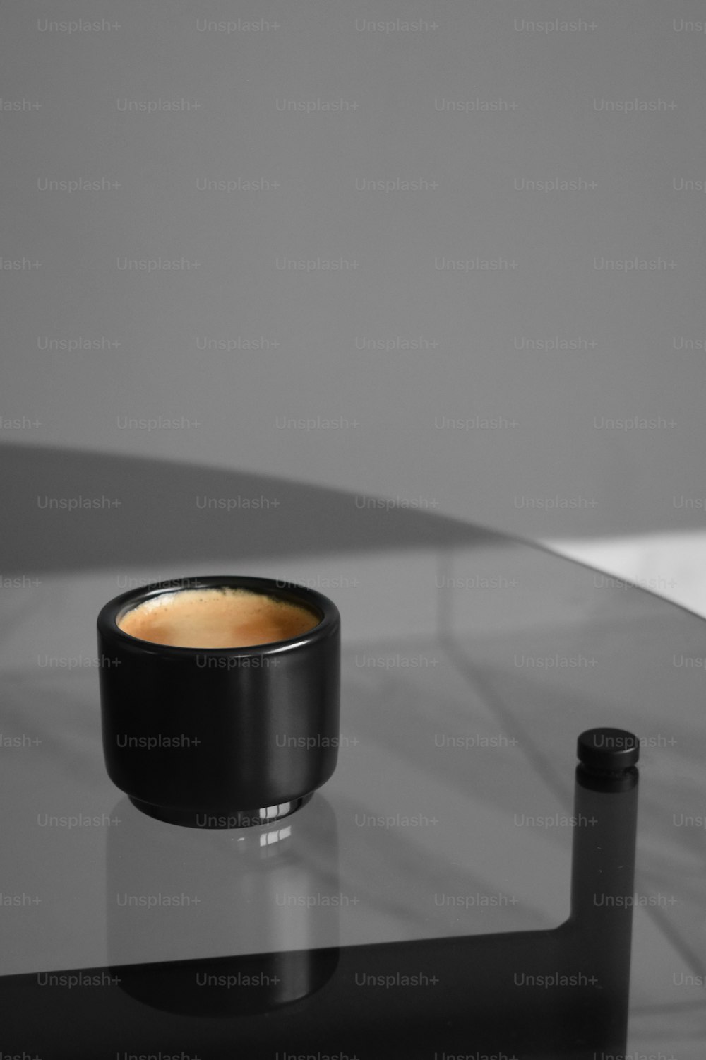 a cup of coffee sitting on top of a glass table