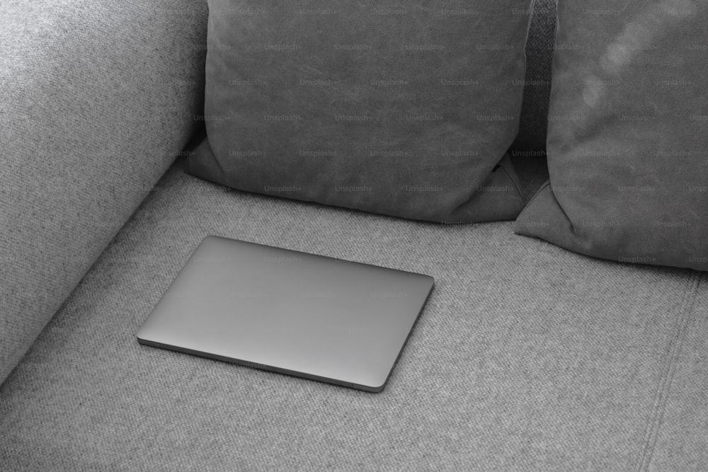 a laptop computer sitting on top of a gray couch