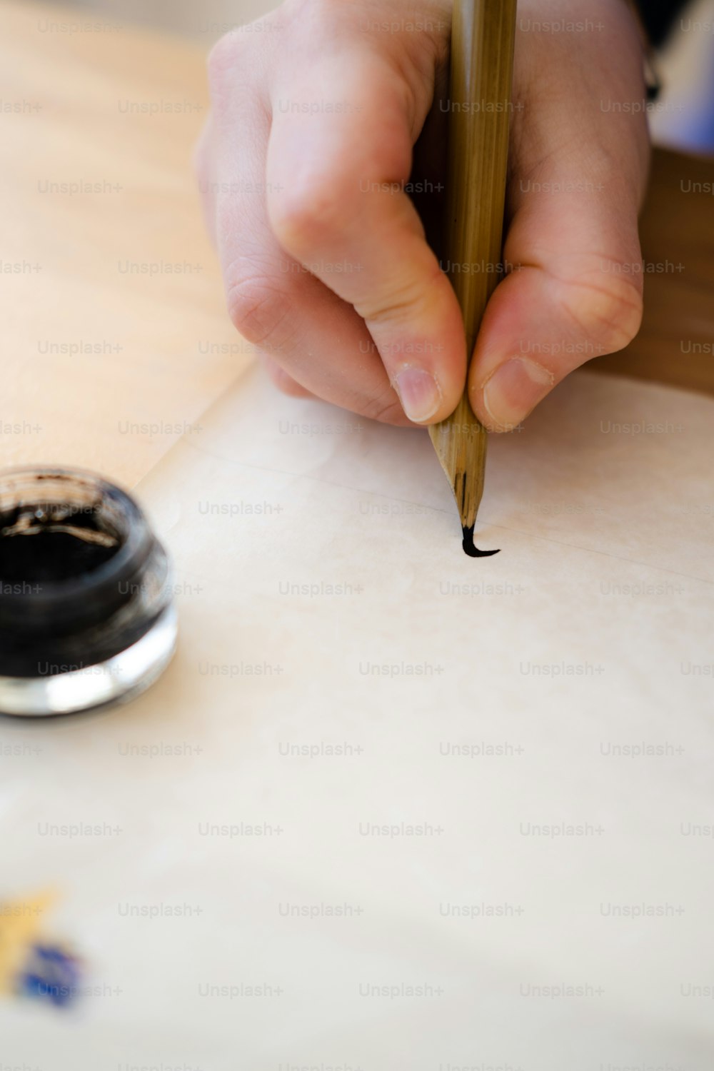 a person writing on a piece of paper with a pen