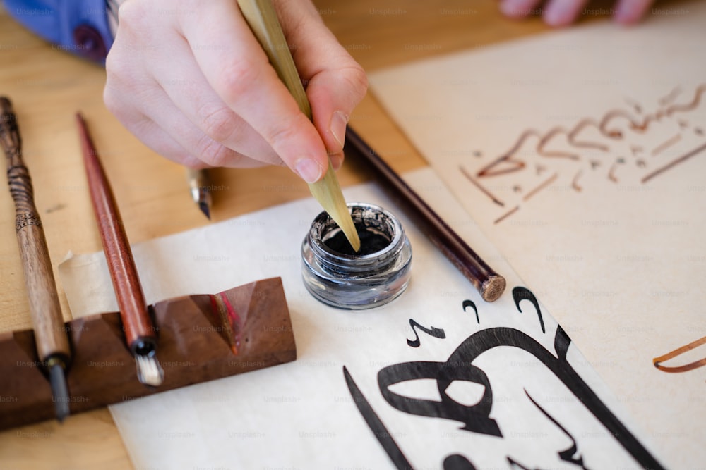 a person writing on a piece of paper with a pencil