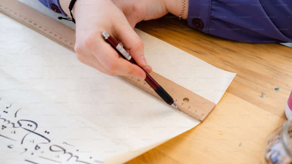 uma pessoa com uma caneta e papel em uma mesa