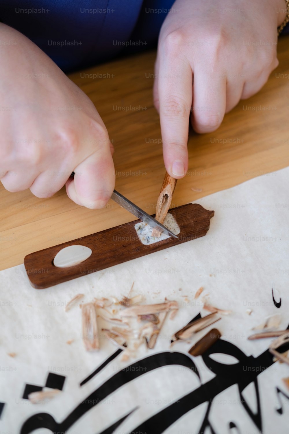 a person cutting wood with a pair of scissors