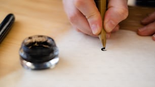 una persona che scrive su un pezzo di carta con una penna