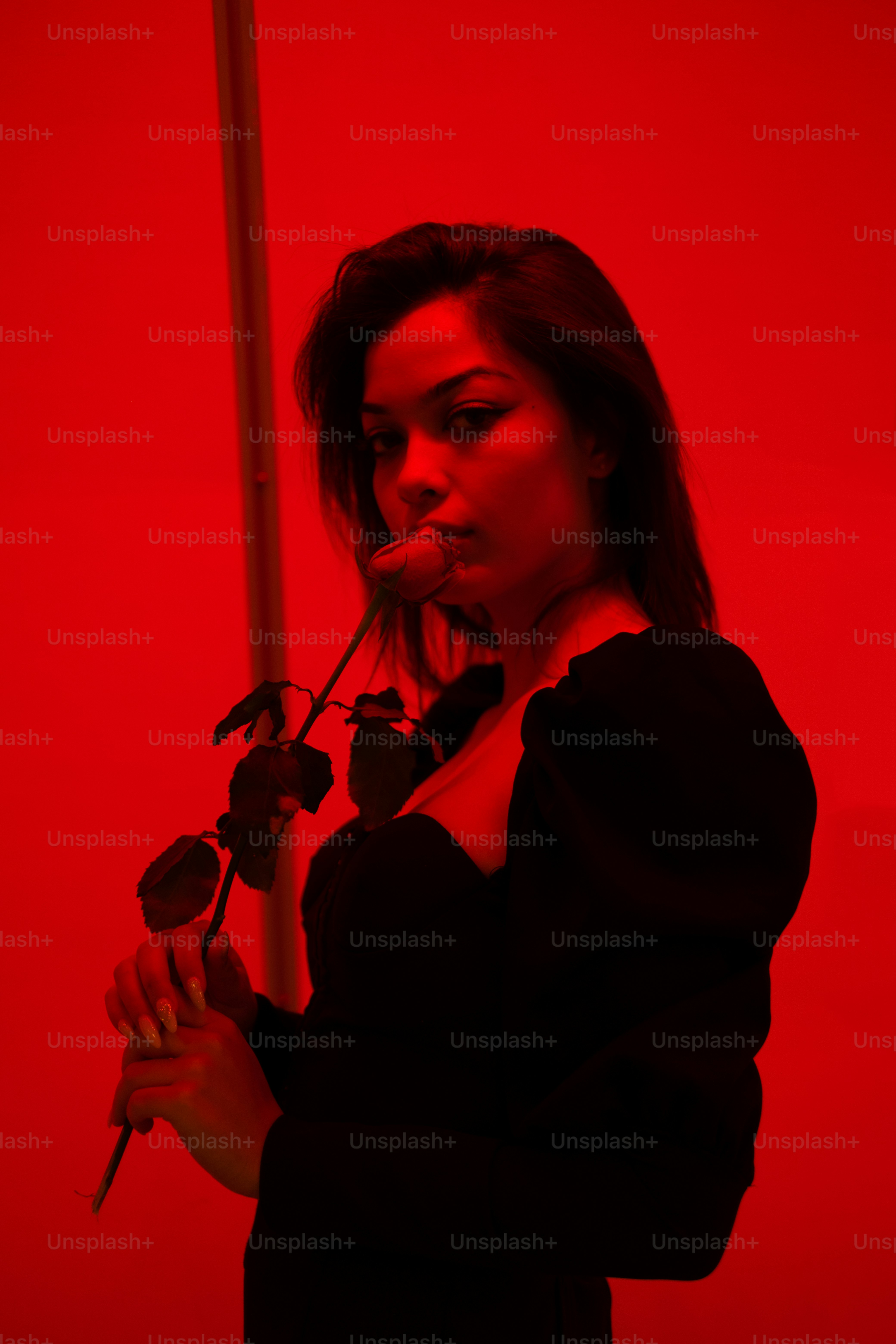 a woman standing in front of a red wall