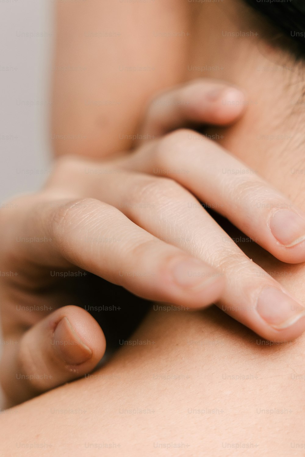 a close up of a person holding their neck