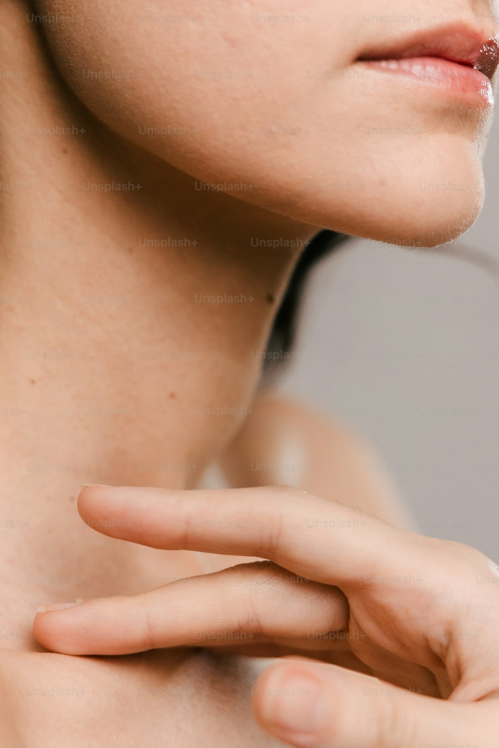 a close up of a woman's neck and hand