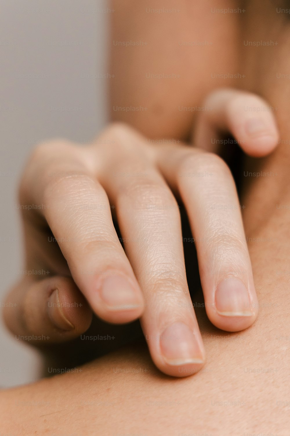 um close up de uma pessoa segurando a mão no ombro