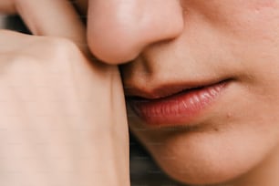 a close up of a woman's face with her hand on her cheek