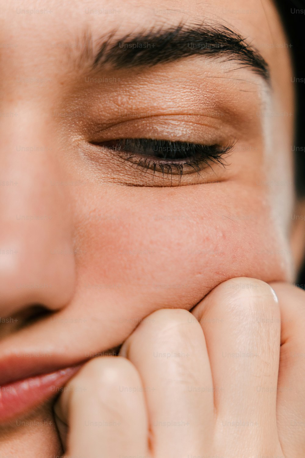 a close up of a woman with her hand on her face