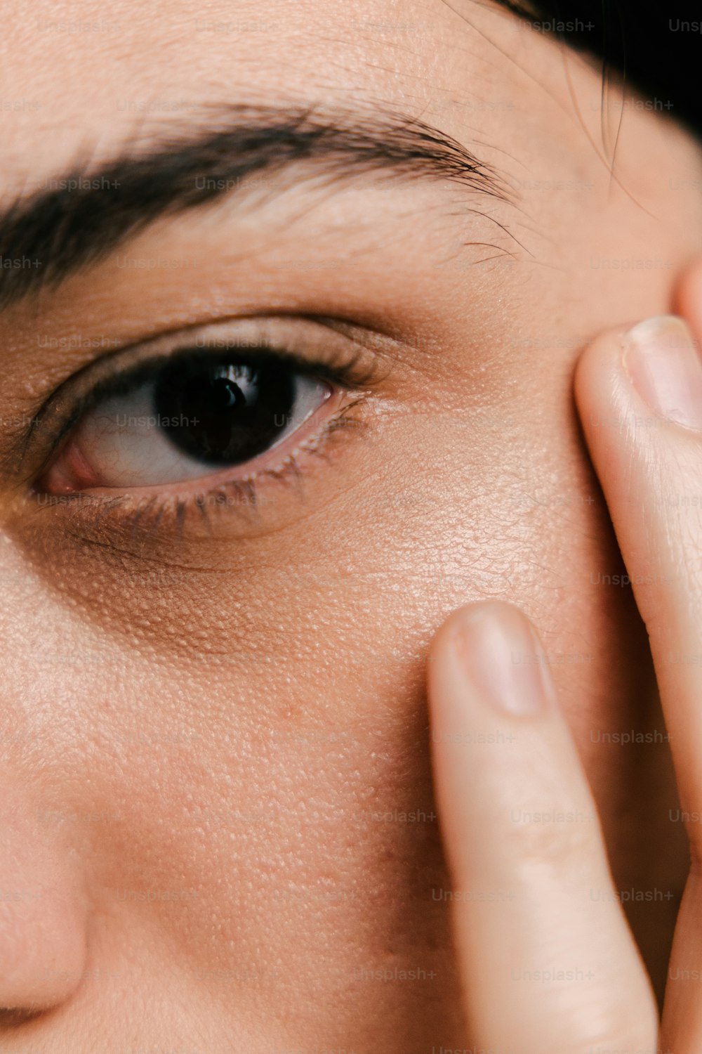 um close up de uma pessoa tocando seu olho