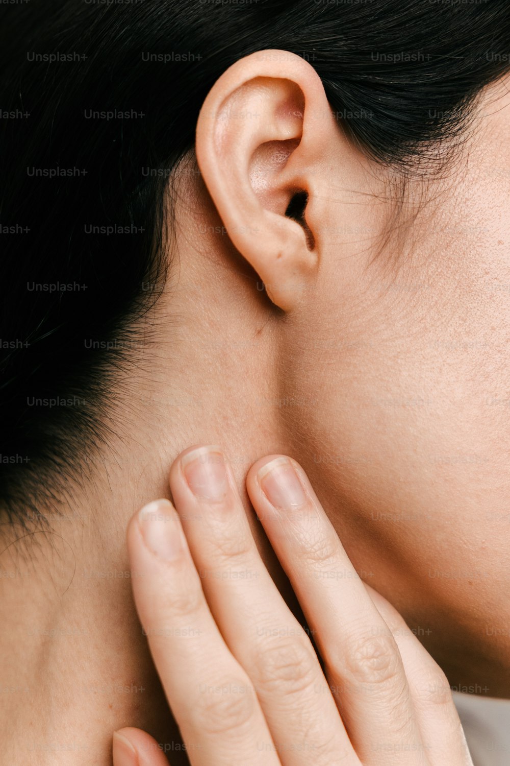 a close up of a person touching their ear