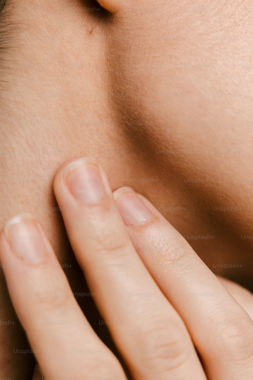 a close up of a woman's neck with her hands on her neck