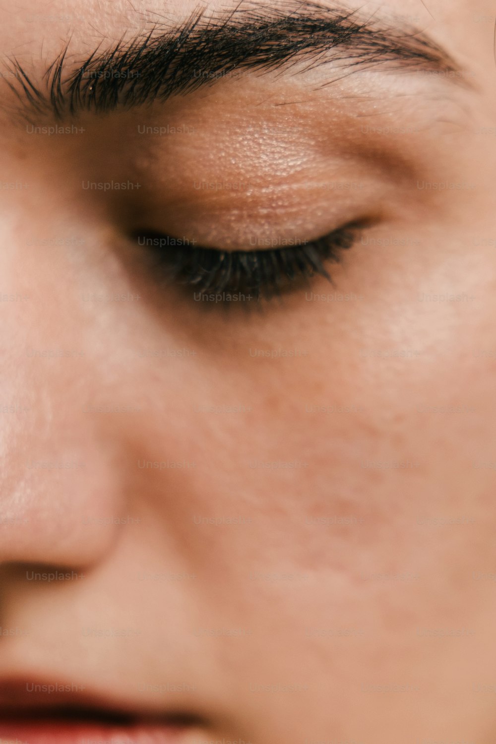a close up of a woman's face with a cell phone in her hand