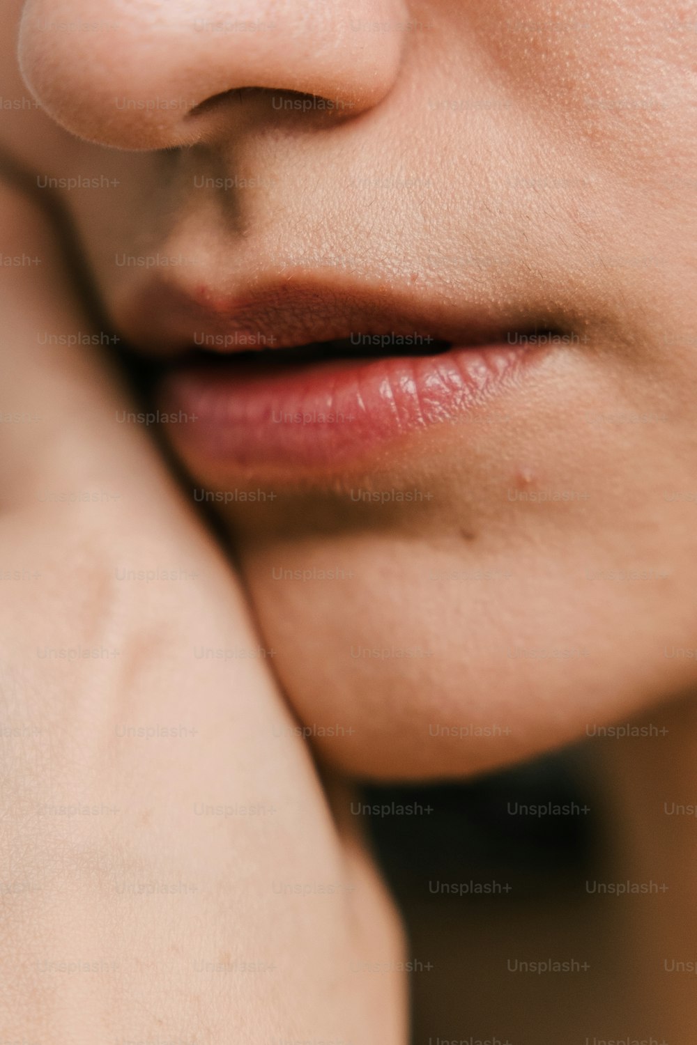 a close up of a woman's face with a ring on her finger