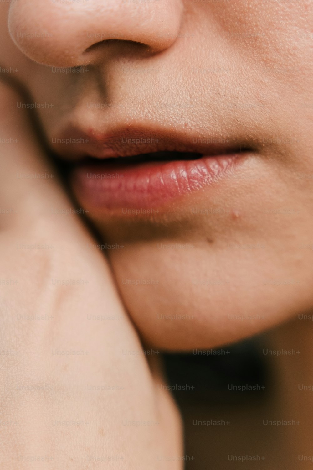 a close up of a woman's face with a ring on her finger