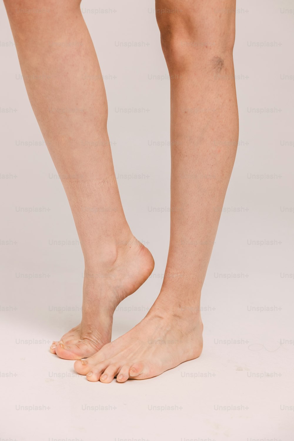 uma pessoa de pé em uma superfície branca com os pés descalços
