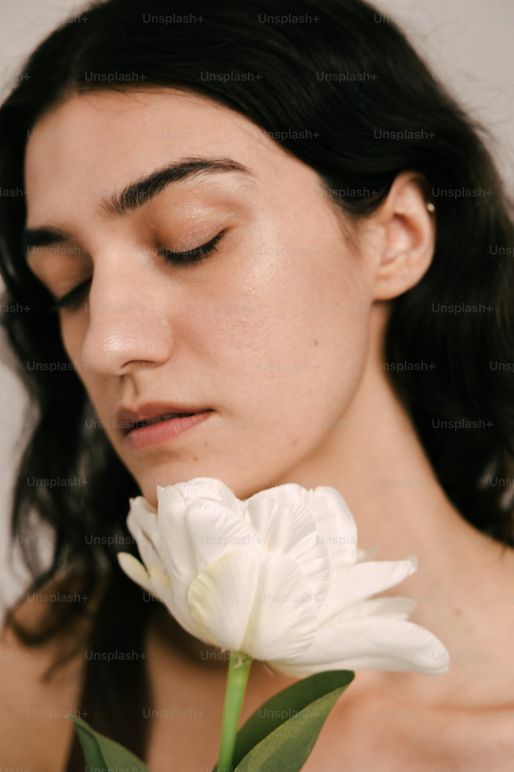 a woman holding a white flower in her hand