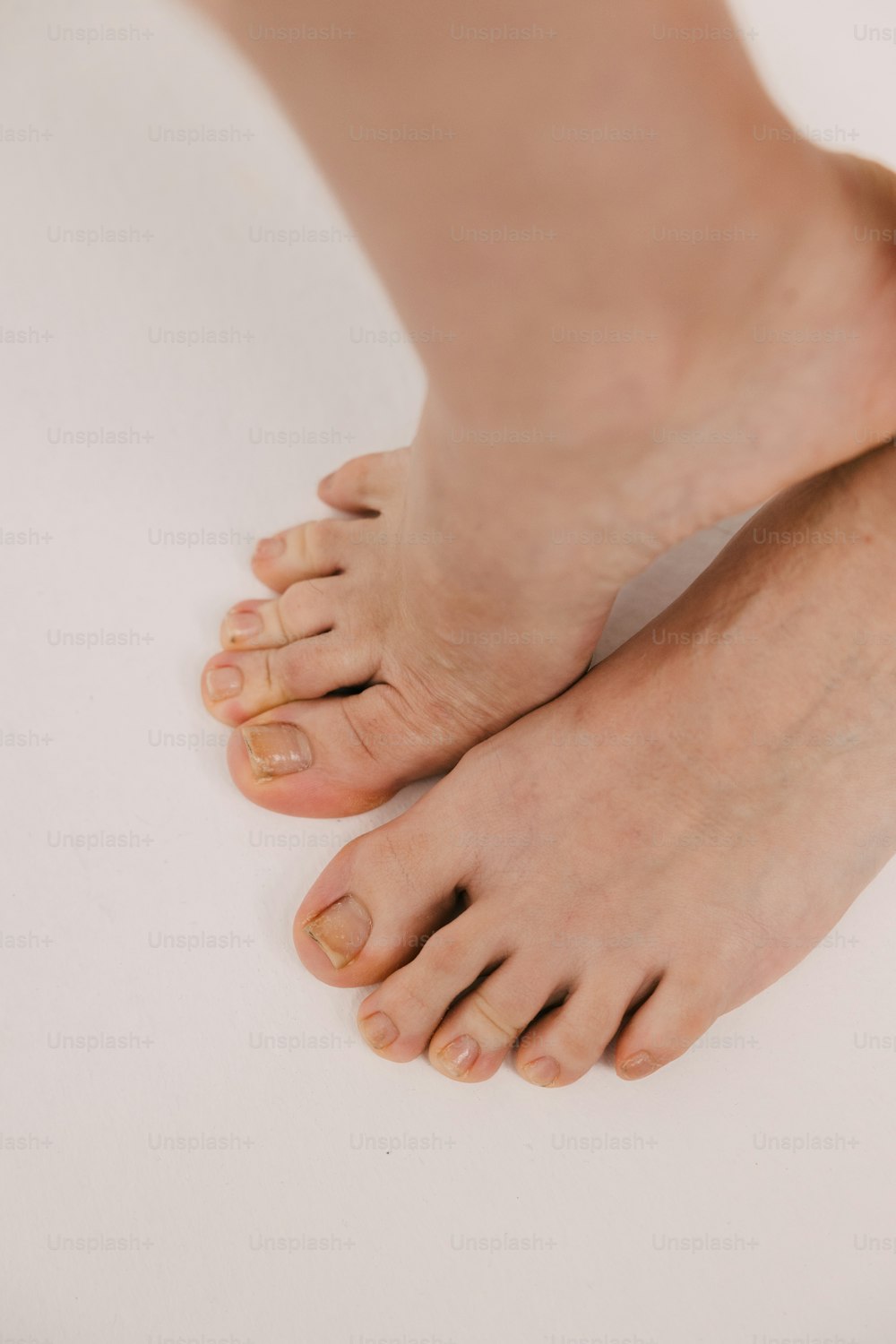 a close up of a person's bare feet on a white surface