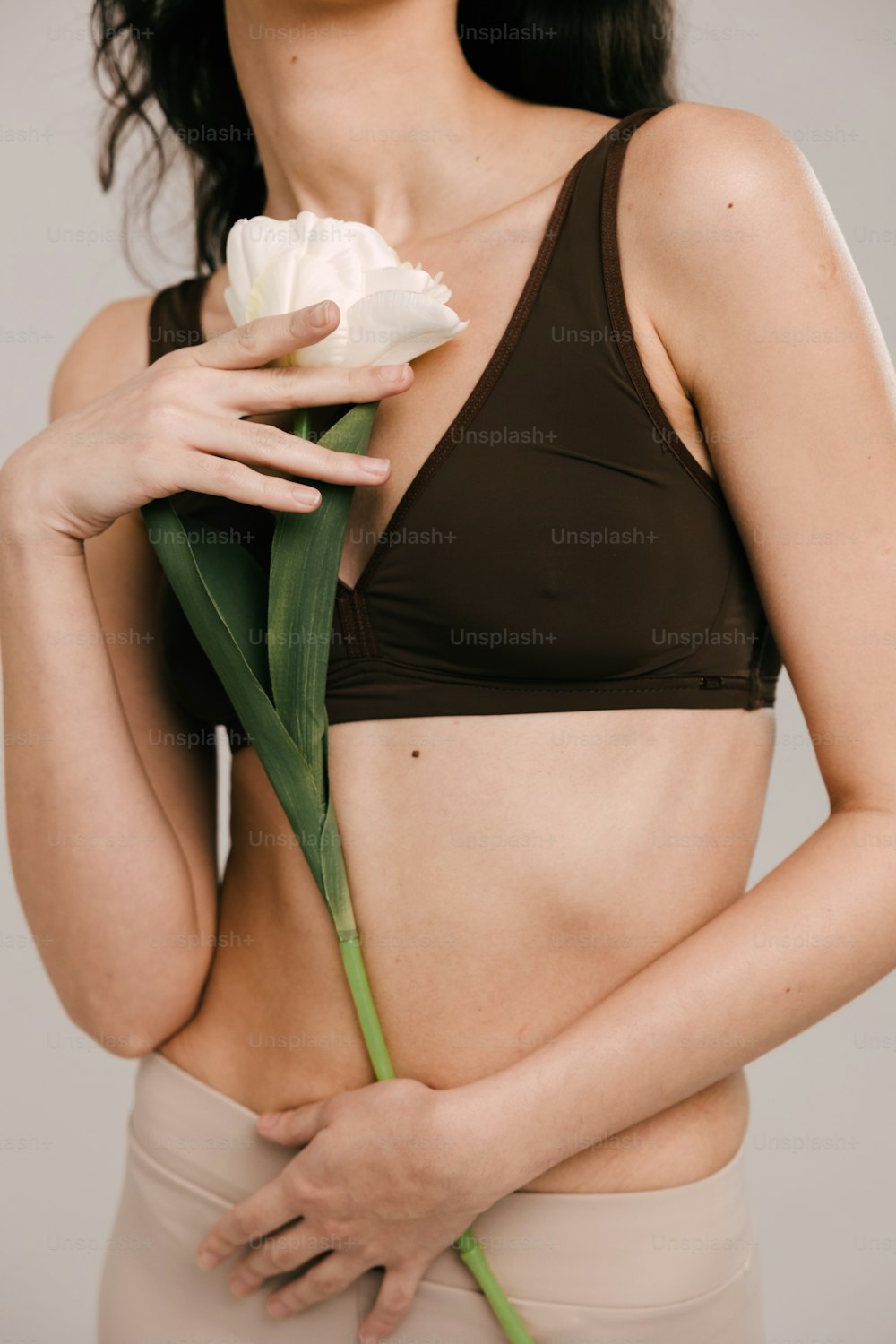 a woman in a bikini holding a flower