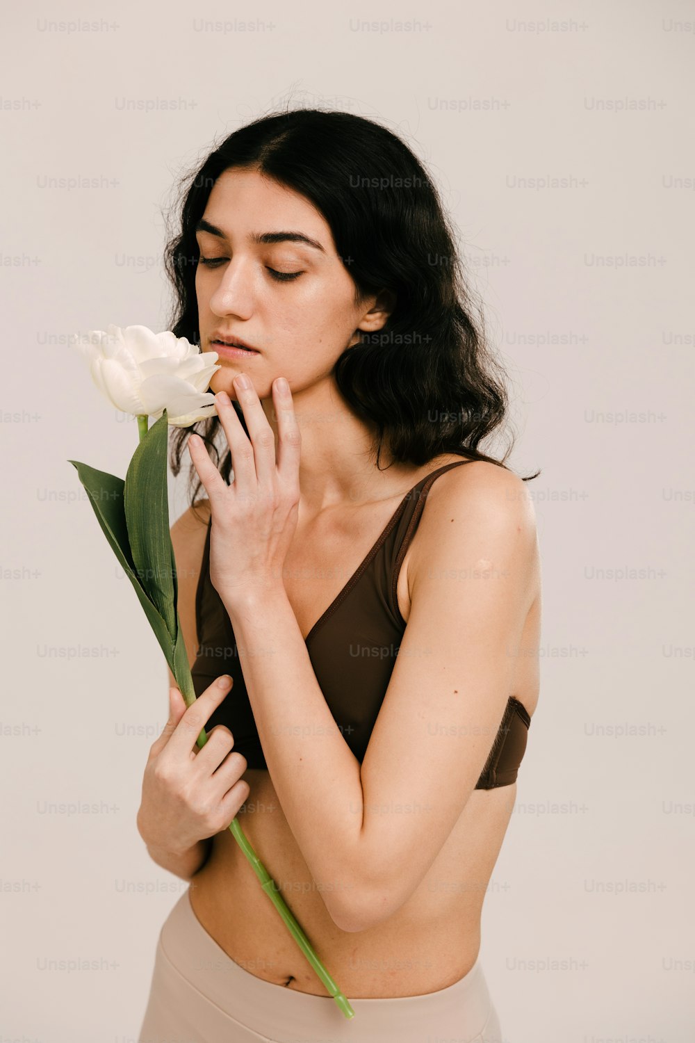 Una mujer sosteniendo una flor en su mano derecha