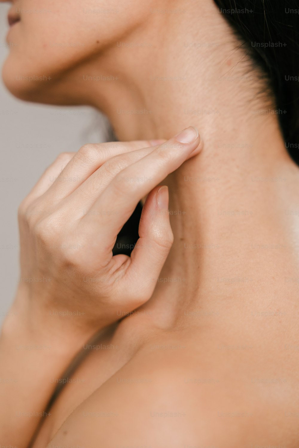 a woman holding her neck up to her chest