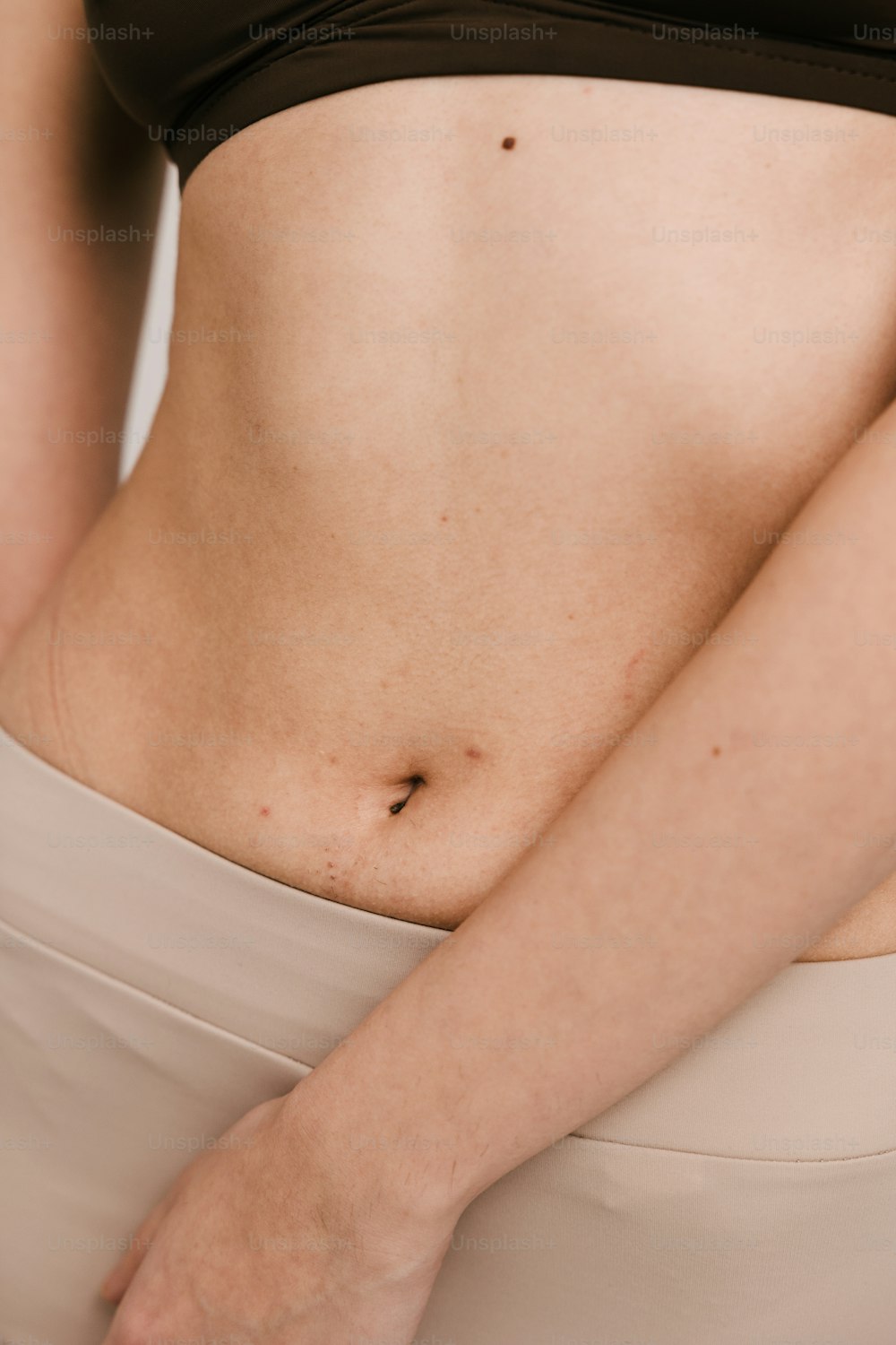 um close up do estômago de uma mulher com a mão no quadril