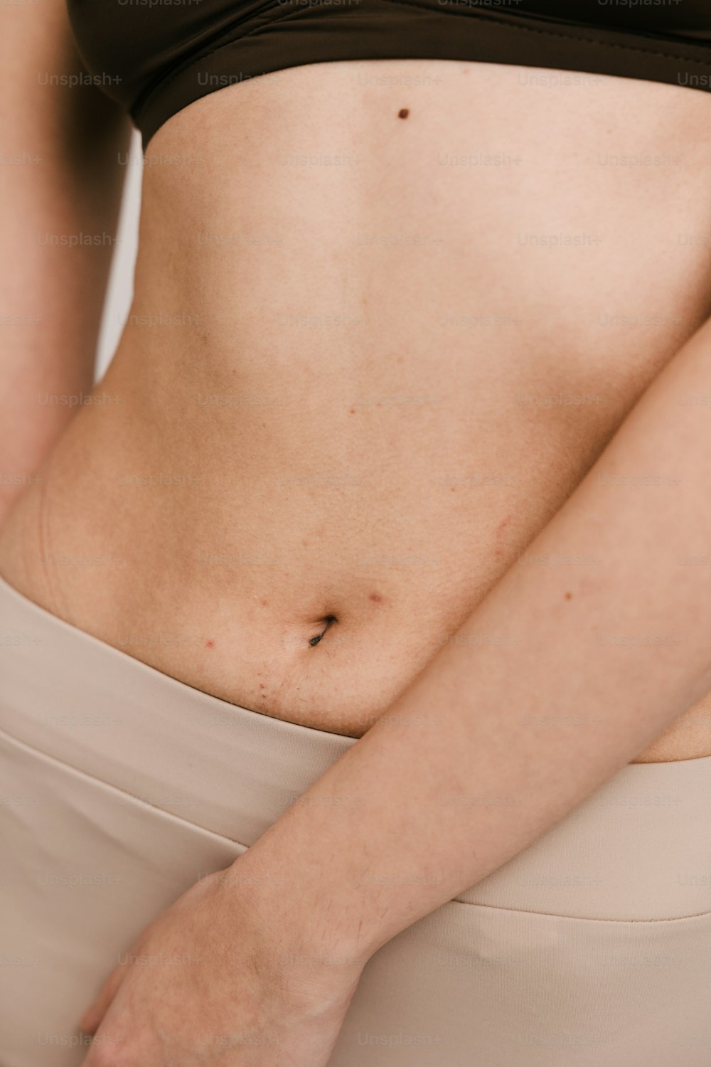 a close up of a woman's stomach with her hand on her hip